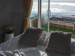 a bed with two pillows in front of a window at ชาเลต์ ภูทับเบิก in Ban Maeo Thap Boek