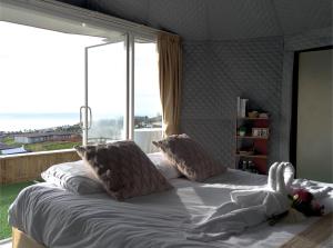 a bedroom with a large bed with a large window at ชาเลต์ ภูทับเบิก in Ban Maeo Thap Boek +18 photos