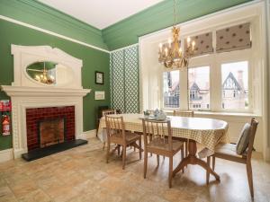 a dining room with a table and a fireplace at Macdui - Mar Lodge Estate in Ballater