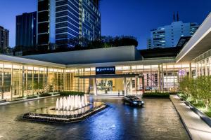 a building with a fountain in front of it at Pullman Bangkok King Power in Bangkok