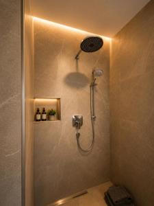 a shower with a shower head in a bathroom at Schongau Suites Premium Apartments M in Schongau