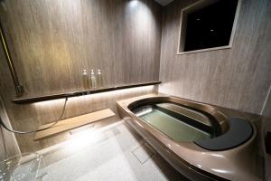 a bathroom with a bath tub and a sink at Mon Hotel HAKATA in Fukuoka