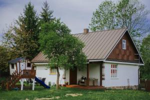 a house with a gambrel roof and a playground at Chata w Kamieniu in Kamień