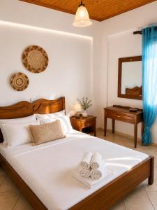 a bedroom with a bed with two towels on it at Meltemi Apartments in Elafonisos