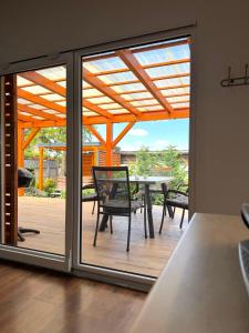 an open patio door with a table and chairs at Chata VeloVino in Moča