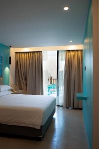 a bedroom with a bed and a large window at Rasgrand in Rasdhoo