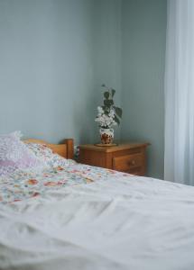 a bedroom with a bed and a vase of flowers on a table at Chata w Kamieniu in Kamień