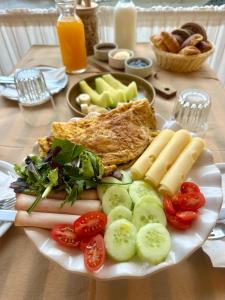 a plate of food with eggs meat and vegetables on a table at Palatino in Loutra Edipsou