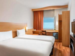 a hotel room with two beds and a television at Ibis Izmir Alsancak in İzmir +79 photos