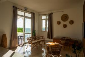 a living room with a table and chairs and a window at Les Manglier in Port Mathurin +44 photos