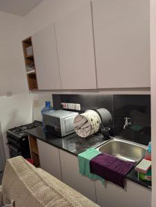 a kitchen with a sink and a microwave at Alchemist Homes in Kiambu