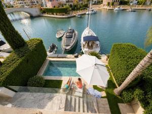 a pool with an umbrella and a boat in the water at FINELINE Villa in Limassol
