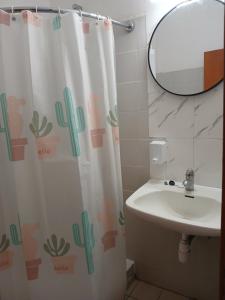a bathroom with a shower curtain with a sink and a mirror at Doukas in Skala Rachoniou