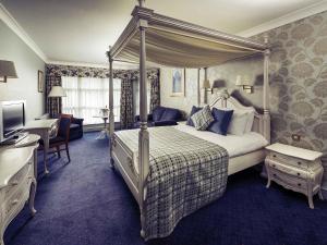 a bedroom with a canopy bed and a television at Mercure Bristol North The Grange Hotel in Bristol +80 photos