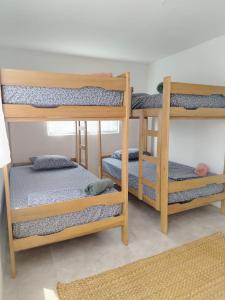 a room with three bunk beds in a room at Cabañas Punta Negra in Punta Negra