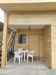a patio with a table and two chairs and a building at Cabañas Punta Negra in Punta Negra