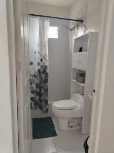 a white bathroom with a toilet and a shower at Cabañas Punta Negra in Punta Negra +25 photos