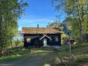 an old house with a grass roof on a road at Stille og fredelig med panoramautsikt in Valsøybotn