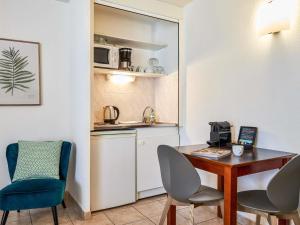 a kitchen with a desk and two chairs and a table at Aparthotel Adagio Access Nice Garibaldi in Nice