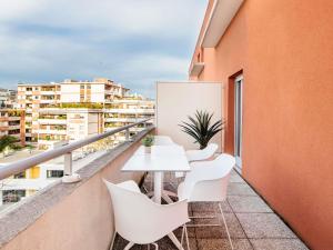 a balcony with a white table and white chairs at Aparthotel Adagio Access Marseille Prado Périer in Marseille
