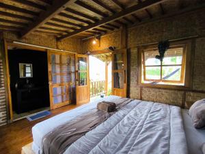 a large bed in a room with a window at Tetebatu Sasak House Bungalow in Tetebatu