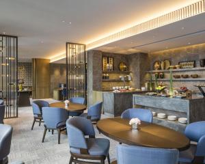 a restaurant with tables and chairs and a counter at Hyatt Centric Victoria Harbour in Hong Kong