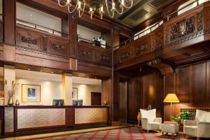 a lobby of a hotel with a reception desk and chairs at Vienna House by Wyndham Thüringer Hof Eisenach in Eisenach