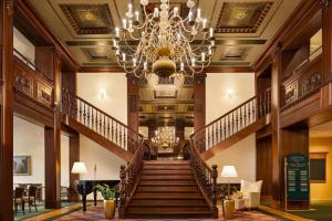 a staircase in a building with a chandelier at Vienna House by Wyndham Thüringer Hof Eisenach in Eisenach