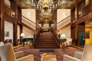 a large lobby with stairs and a chandelier at Vienna House by Wyndham Thüringer Hof Eisenach in Eisenach +133 photos