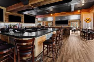 a bar in a restaurant with wooden floors and chairs at Ramada by Wyndham Arnprior in Arnprior