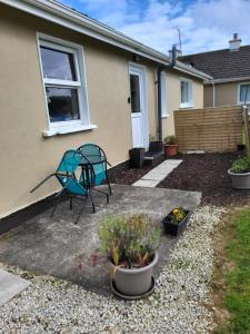 a patio with a blue chair and some plants at Beech Lodge,Garden Apartment in Goffʼs Bridge