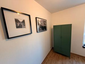 a room with a green cabinet and pictures on the wall at Gartenwohnung im Kuhstall, Havelzugang, Vollausstattung in Ketzin +10 photos