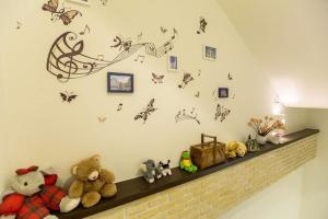 a shelf with stuffed animals and butterflies on a wall at 懶羊羊民宿Cozy Sheep in Chishang