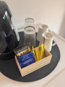a tray with a tea pot and a box of packets at Denmark Waterfront Lodge in Denmark +6 photos