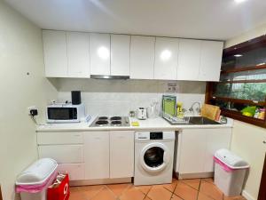 a kitchen with white cabinets and a washing machine at Room 31 in Sydney