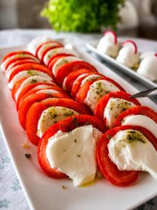 a white plate of food with red peppers and cheese at Pasja Dom Wypoczynkowy Świeradów - Zdrój w górach in Świeradów-Zdrój