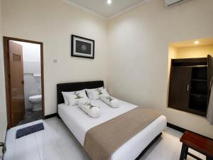 a bedroom with a white bed and a toilet at Abadi Homestay Yogyakarta in Yogyakarta +21 photos