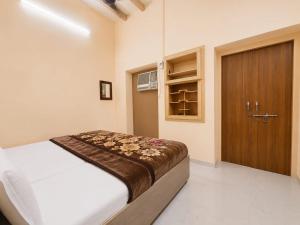 a bedroom with a bed and a wooden door at Hotel Jannat Palace in New Delhi