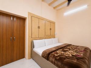 a bedroom with a bed and a wooden cabinet at Hotel Jannat Palace in New Delhi +6 photos