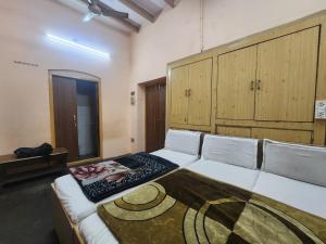 a room with two beds in a room with wooden cabinets at Hotel Jannat Palace in New Delhi