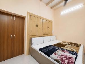 a bedroom with a bed and a wooden cabinet at Hotel Jannat Palace in New Delhi