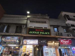 a building with signs on the side of it at night at Hotel Jannat Palace in New Delhi