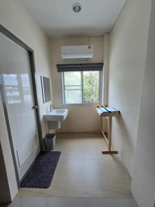 a bathroom with a sink and a window at Buddy Hostel in Chiang Rai