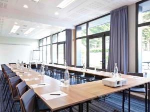 a large conference room with long tables and chairs at ibis Styles Quiberon Centre in Quiberon +86 photos