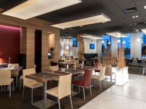 a restaurant with tables and chairs in a room at Novotel Sofia in Sofia