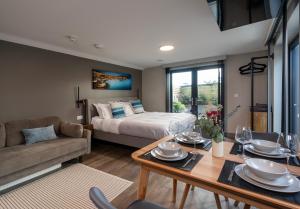 a bedroom with a bed and a table and a couch at Uno Carbis Bay - Boutique Luxury Accommodation in Carbis Bay