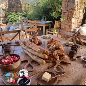 a wooden table with bread and other food on it at Casa Olea in Sartène