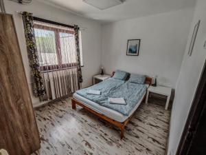 a bedroom with a bed and a window at Artemis Vendégház in Bogács