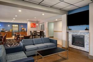 a living room with a couch and a fireplace at Baymont by Wyndham Waukesha in Waukesha