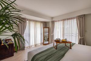 a bedroom with a bed with a table and a plant at Beyond The Blue Horizon Boutique Bungalows in Haad Chao Phao